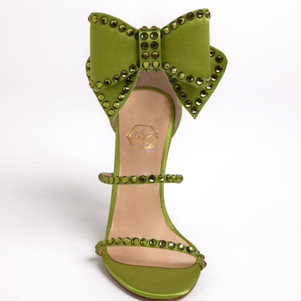 Luxury green sandal with adjustable bow detail worn in front
